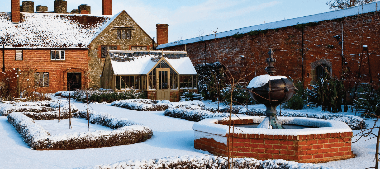 Alitex Greenhouse sitting upon frosty snowy walled garden