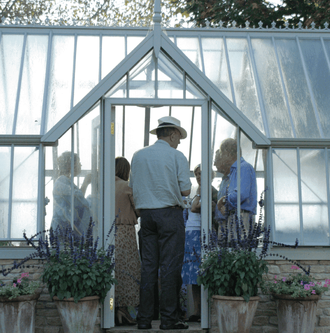 People viewing Alitex Mottisfont greenhouse on open morning