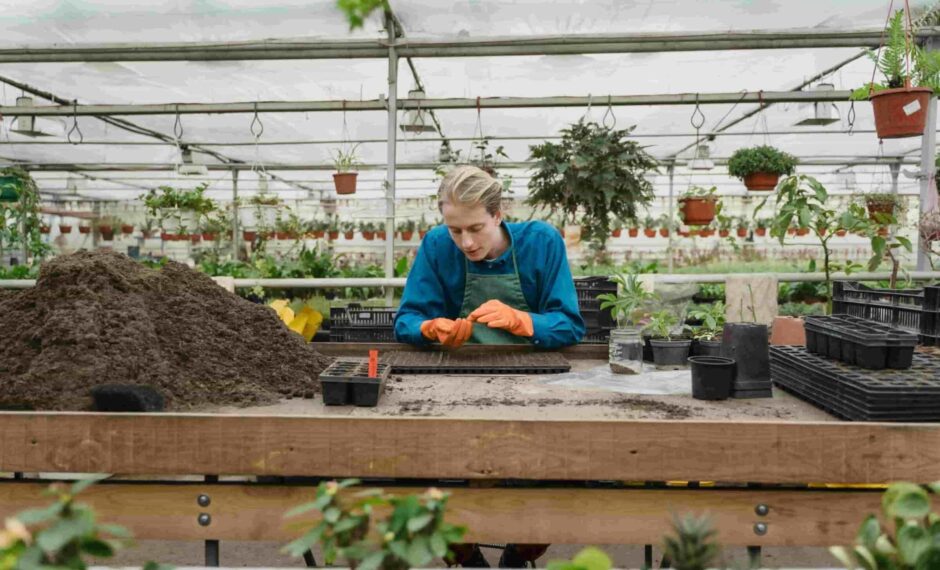 Sustainable Gardening: Gardener leaning on bench playing with soil